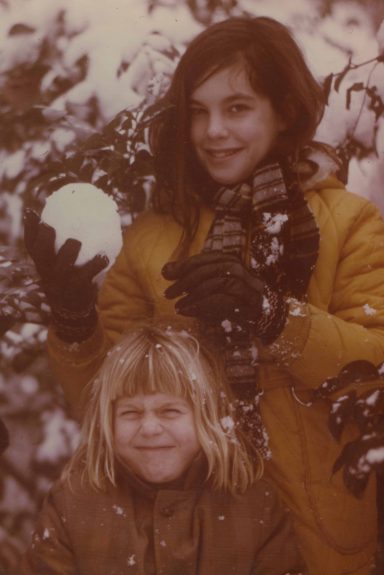 two girls in the snow with a snowball