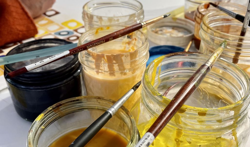 Jars filled with watercolor pigments on studio worktable.